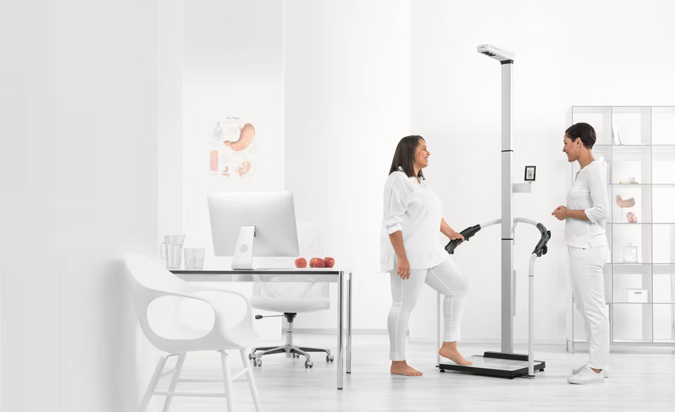 Coach and patient talking near machine